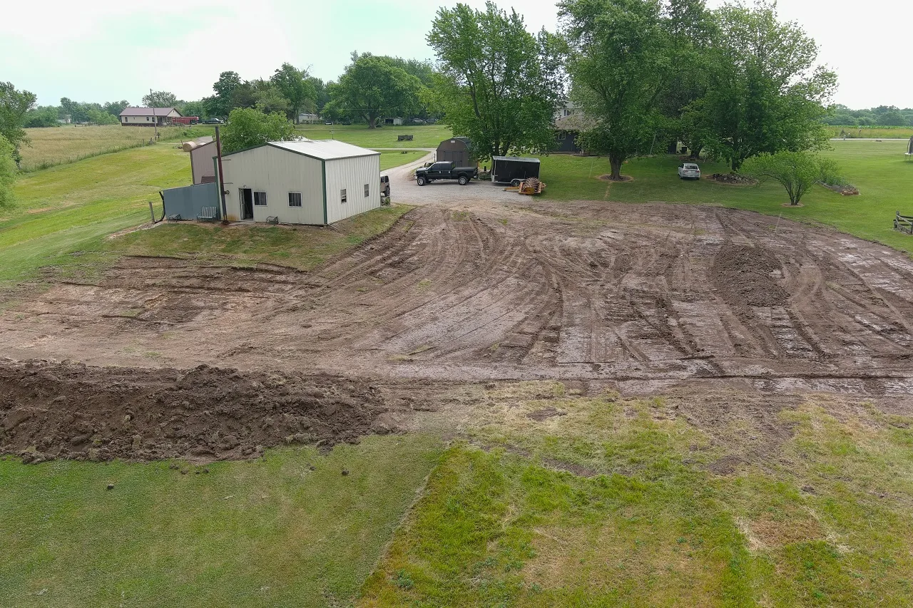 Dirt pad graded flat beside a metal shop building