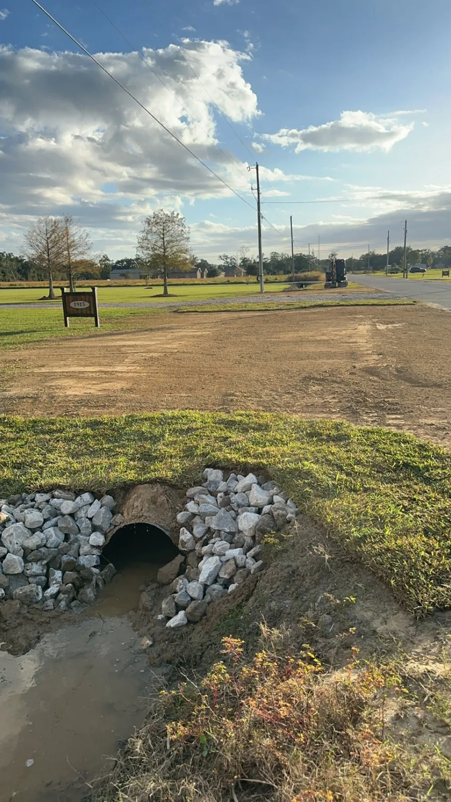 Driveway culvert finished with a rock headwall and graded approach